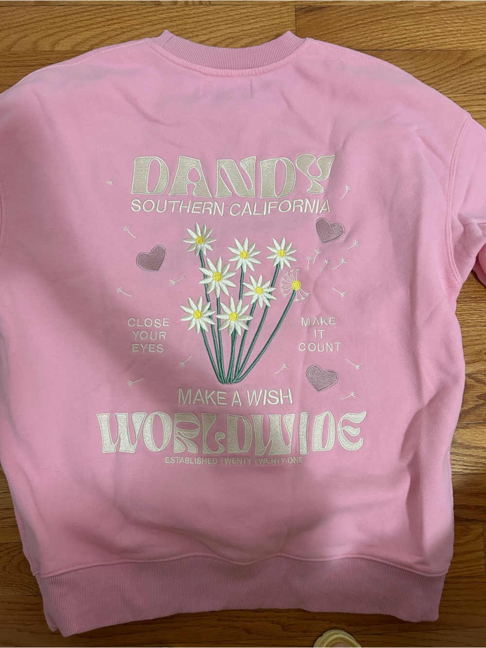 Dandy pink crewneck sweatshirt with flowers, white daisies, and text graphic